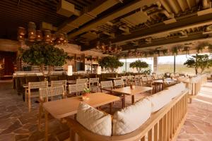 a restaurant with wooden tables and white chairs at Van Der Valk Luxembourg Arlon in Arlon