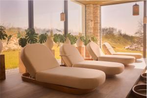a waiting room with white chairs and large windows at Van Der Valk Luxembourg Arlon in Arlon +77 photos