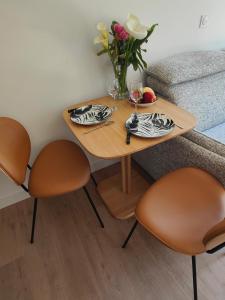 a table with two chairs and a vase of flowers at L'Escale in Penvénan +5 photos