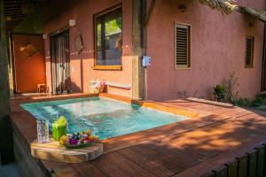 a swimming pool on a wooden deck with a table with a bowl of fruit at Villa Arumã Pousada in Alter do Chao