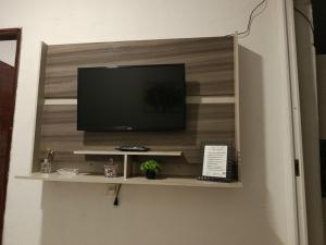 a television on a shelf in a room at Casa de clecia in Natal
