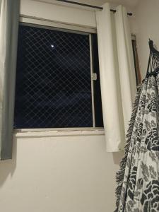 a window in a room with a curtain at Casa de clecia in Natal