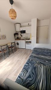 a bedroom with a zebra patterned bed and a kitchen at CHROMA - Studio Nantes GARE SUD in Nantes