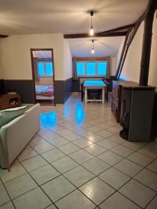 a living room with a tile floor and a table at le sans soucis in Bellevaux