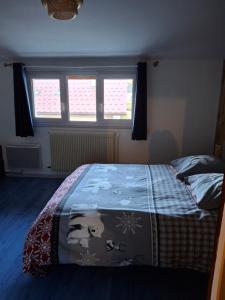 a bedroom with a bed with a blanket on it at le sans soucis in Bellevaux