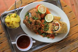 a plate of food on a tray on a table at Cleopatra Gardens in Kampala