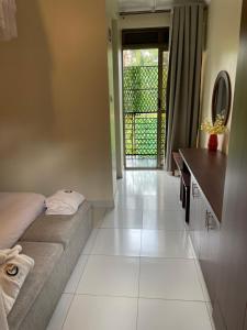 a bedroom with a bed and a desk and a mirror at Cleopatra Gardens in Kampala