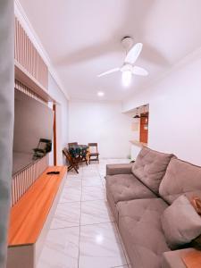 a living room with a couch and a ceiling fan at Apartamento Mirim Praia Grande in Praia Grande