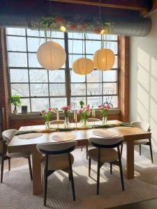 a dining room with a table and chairs and windows at Charming Urban Zen in Cleveland