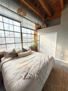 a large bed in a room with large windows at Charming Urban Zen in Cleveland