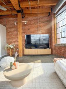 a living room with a large tv on a brick wall at Charming Urban Zen in Cleveland