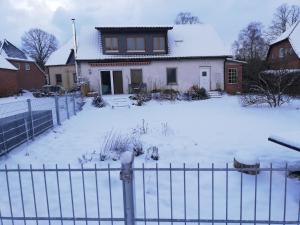 a house with a snow covered yard with a fence at Perdöhl-Wittenburg in Wittenburg