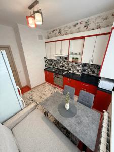 a small kitchen with red cabinets and a table at New House Strișca in Chişinău