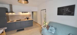 a living room with a blue couch and a kitchen at Loveroom in Lavoux