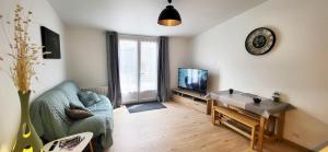 a living room with a couch and a tv at Loveroom in Lavoux