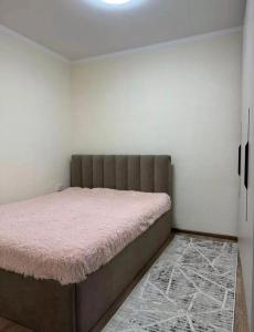 a bedroom with a large bed with a pink blanket at Радуга in Chon-Sary-Oy
