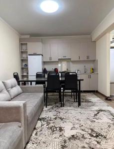 a living room with a couch and a table and a kitchen at Радуга in Chon-Sary-Oy