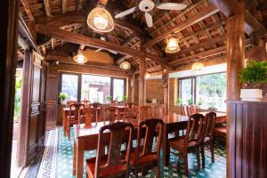 a dining room with a long table and chairs at Champs De Tam Coc Hotel in Vũ Lâm