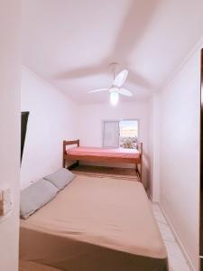 a bedroom with a bed and a ceiling fan at Apartamento Mirim Praia Grande in Praia Grande