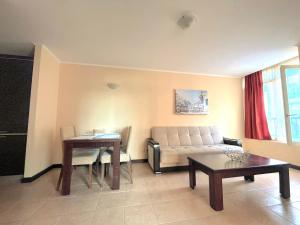 a living room with a couch and a table at Красавиците тъмнокоси Sunset Family in Pomorie