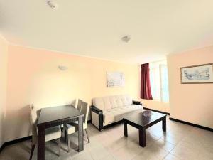 a living room with a couch and a table at Красавиците тъмнокоси Sunset Family in Pomorie +7 photos