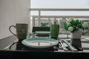 a table with plates and utensils on a table at Assinie's apartment in Assinie