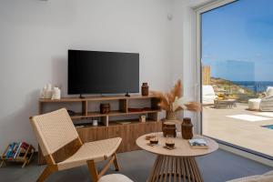 a living room with a television and a table and chairs at villa yasmin luxury in Bali