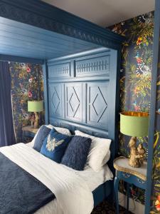 a blue bedroom with a bed with a blue headboard at Durham Central Suites in Gilesgate