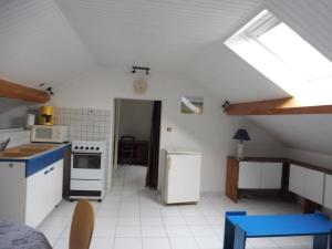 a kitchen with a stove and a refrigerator at Au Pied du Cognelot in Chalindrey