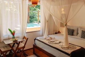 a bedroom with a canopy bed and a window at Villa Arumã Pousada in Alter do Chao +162 photos