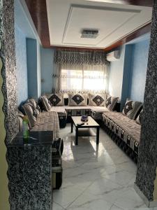 a living room with couches and a coffee table at Apartment sunah in Nador