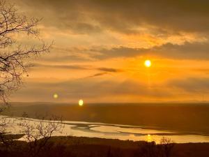 a sunset with the sun setting over a body of water at GABRIELLE HOTEL in Aiguines