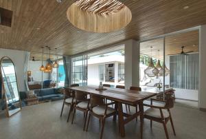 a dining room with a wooden table and chairs at The Avlu Modern Spa Retreat in Tanah Lot