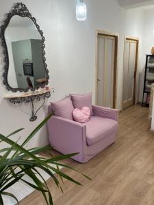 a purple couch in a room with a mirror at Sotto la Cupola in Montefiascone
