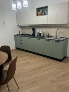 a kitchen with white cabinets and a wooden floor at Sotto la Cupola in Montefiascone