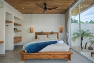 a bedroom with a bed and a ceiling fan at The Avlu Modern Spa Retreat in Tanah Lot +72 photos