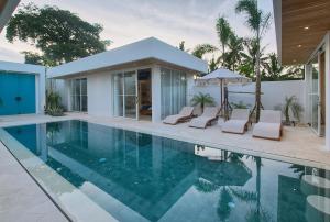 a house with a swimming pool and a house at The Avlu Modern Spa Retreat in Tanah Lot