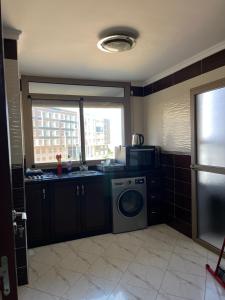 a kitchen with a sink and a washing machine at Apartment sunah in Nador