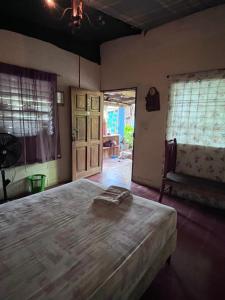 a bedroom with a bed and a window and a chair at Punta Roca Surf House in El Majahual