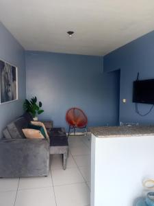 a living room with a couch and a blue wall at Refúgio no Centro in Imperatriz
