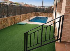 a swimming pool with a fence and green grass at El Respiro in Ruidera