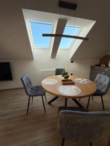 a dining room with a table and chairs and a skylight at Apartma Luvita in Golnik