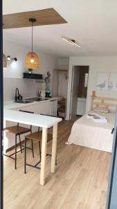 a kitchen and living room with a table and a bed at Seabird Lisbon Studio in Charneca