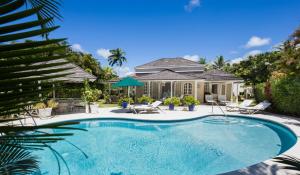 a swimming pool in front of a house at Royal Westmoreland Lonetrees - by ZenBreak in Saint James
