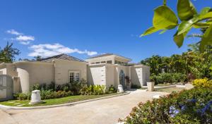 a large white house with a driveway at Royal Westmoreland Lonetrees - by ZenBreak in Saint James