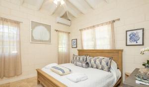 a bedroom with a bed with two pillows on it at Royal Westmoreland Lonetrees - by ZenBreak in Saint James +19 photos