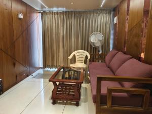 a living room with a couch and a chair at Agatya Homestay in Kolhapur +1 photo