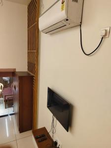 a living room with a tv on a wall at Agatya Homestay in Kolhapur