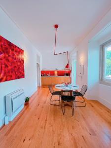 a living room with a table and chairs and a painting at Casa René - Charming apartments in Almada +114 photos