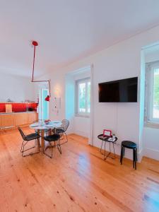 a living room with a table and chairs at Casa René - Charming apartments in Almada